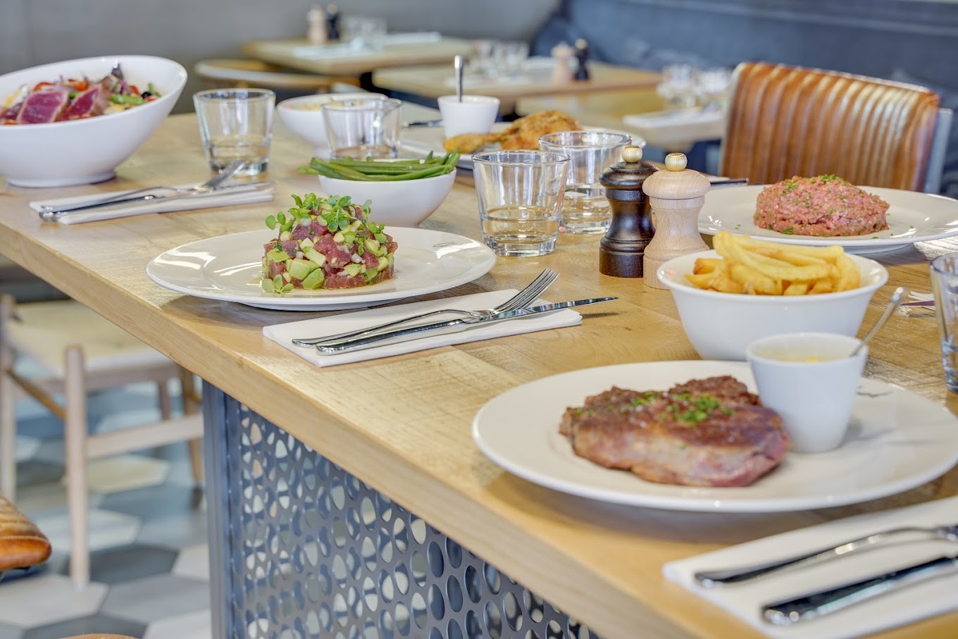 Table en bois du restaurant Le Choupinet avec plusieurs plats froids et chauds