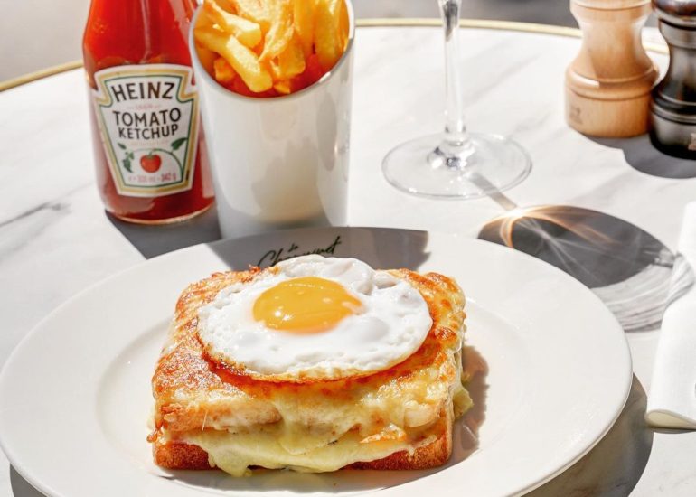 Croque Choupinette, croque-monsieur revisitée avec un œuf au plat dessus, une portion de frites maison, du ketchup, un verre de rosé, sel et poivre sur la terrasse du restaurant Parisien Le Choupinet